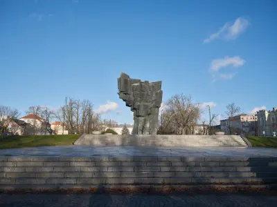 Monumentalny pomnik Obrońców Płocka 1920 roku na wysokim postumencie ze schodami, w otwartej przestrzeni miejskiej zimą