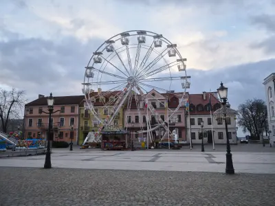 Diabelski młyn na tle kolorowych kamienic Starego Rynku w Płocku, zimowy dzień, pusty brukowany plac i dekoracyjne latar