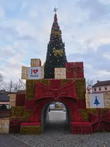 Wysoka świąteczna choinka z łukiem z dekoracyjnych prezentów na Starym Rynku w Płocku