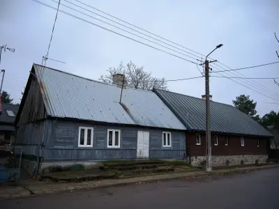 Drewniany dom z blaszanym dachem przy ulicy Klasztornej w Czerwińsku nad Wisłą, widok z ulicy
