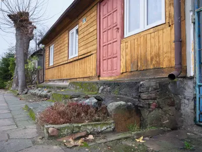 Drewniany dom przy ulicy Klasztornej w Czerwińsku nad Wisłą z kamiennymi schodami i ceglanym podestem